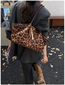 Modische Shopper-Tasche mit Leopardenmuster, Holzperlen-Anhänger und braunen Riemen im Freien