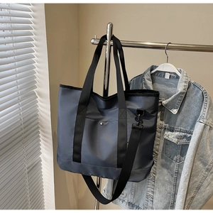 Detail of navy blue nylon tote bag with reinforced handles and adjustable wide strap