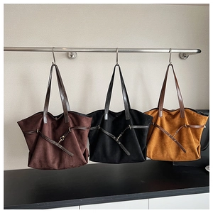 Detailed view of large suede tote bags in brown, black, and caramel with leather straps
