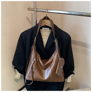 Detailed view of brown vintage Hobo bag with side zipper pocket and mini pouch charm