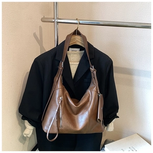 Detailed shot of brown vintage PU leather hobo bag with front zip pocket and mini pouch