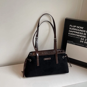 Detail view of black frosted tote bag with dark brown leather handles and side drawstrings