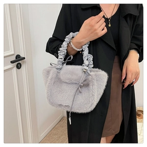 Detail of grey plush handbag with soft faux fur texture and pleated cloud handle