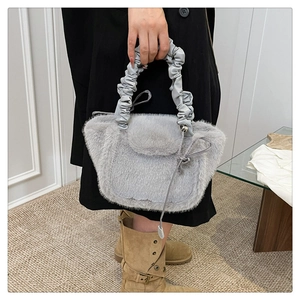 Detailed shot of plush gray faux fur handbag with stylish pleated leather handle