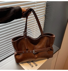 Detailaufnahme einer dunkelbraunen matten Shopper-Tasche mit modischen Schnallen