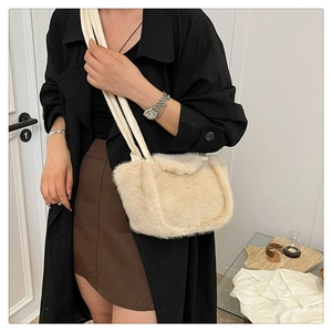 Detail of plush beige shoulder bag with soft faux fur texture and white leather straps