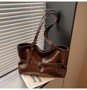 Detail der dunkelbraunen Totebag mit silberner Schnalle und weicher Lederstruktur