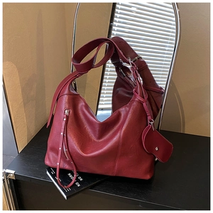 Close-up of a burgundy leather Hobo bag with silver zipper and heart-shaped charm