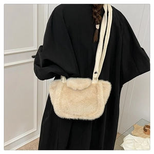 Model wearing a fuzzy cream plush shoulder bag with smooth strap for autumn winter