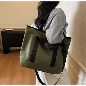 Olive green nylon tote bag featuring wide black straps and side MUJO brand label