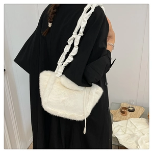 Detail of the soft white faux fur texture and elegant ruched shoulder strap of this bag