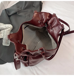 Detail der weinroten Beuteltasche mit gestreiftem Futter, Kordelzug und geräumigem Inneren