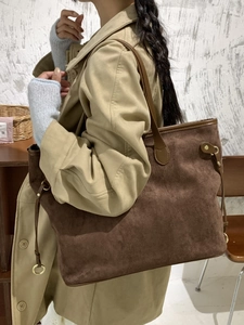 Brown suede tote bag with leather handles and gold metal details for daily commuting