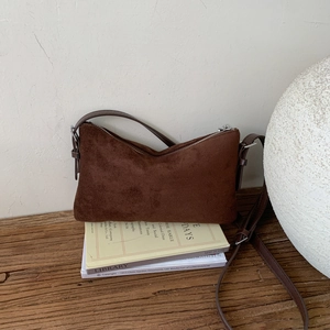 Gros plan d'un sac sous les aisselles en daim mat marron foncé vintage avec zip