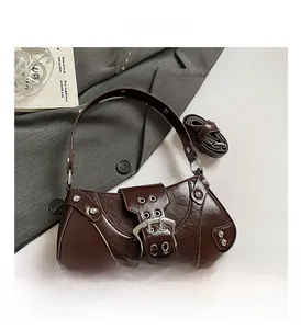 Detail of dark brown vintage faux leather shoulder bag with silver buckles and rivets