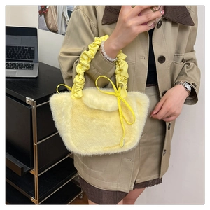 Detail of light yellow fuzzy faux fur tote bag with stylish ruffled handle and drawstring