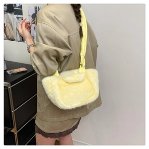 Detailed close-up of bright yellow plush shoulder bag texture and leather strap on model