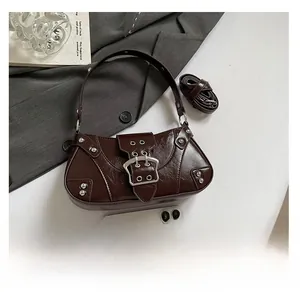Macro view of vintage dark brown baguette bag with silver buckles and pleated leather texture