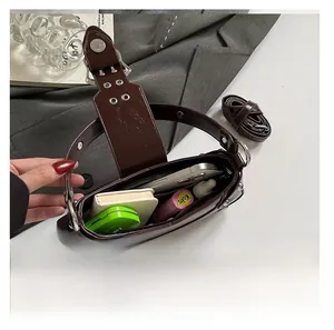 Top view of dark brown biker bag showing spacious interior with daily essentials and strap