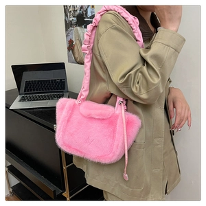 Detail of pink faux fur shoulder bag with ruched leather strap on khaki trench coat