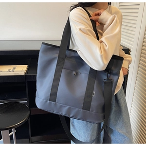 Macro detail of large grey-blue canvas tote bag with adjustable shoulder strap