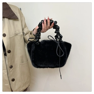 Detail of black faux fur handbag with ruched leather handle and drawstring closure