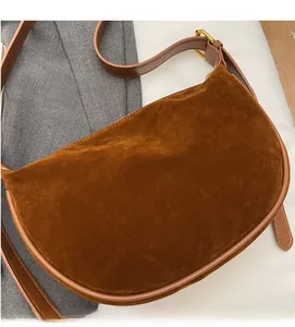 Detailed close-up of brown suede hobo bag with smooth leather trim and golden buckle