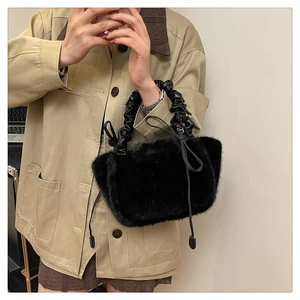 Detail view of black faux fur handbag with scrunchie handle and drawstring accent