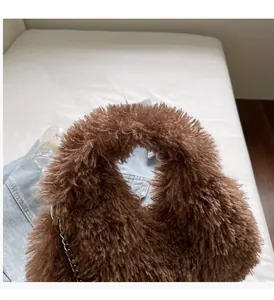 Nahaufnahme der braunen Lammwoll-Tasche mit Silberkette für einen modischen Herbst-Look