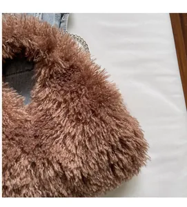Nahaufnahme einer braunen Plüschtasche mit einem Schultergurt aus silberner Metallkette