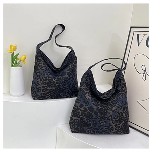 Close-up of leopard print tote bags in dark navy and coffee tones on a white display stand