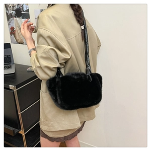 Detail of soft black faux fur shoulder bag with leather strap for autumn winter style