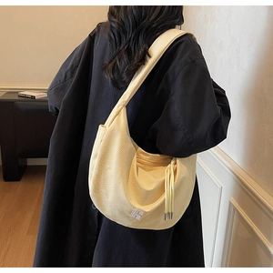 Detail of light yellow waffle fabric hobo bag with white R logo and adjustable drawstring