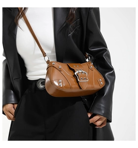 Détails du sac en cuir marron vintage avec boucles argentées et rivets métalliques