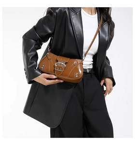 Détail du sac à bandoulière marron vintage avec boucle argentée et rivets décoratifs