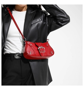 Détail d'un sac bandoulière Y2K en cuir rouge brillant avec rivets et boucles argent
