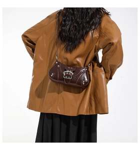 Détail du sac sous l'aisselle vintage marron foncé avec boucles argentées sur mannequin