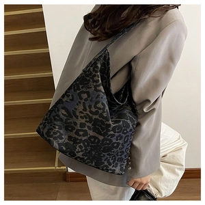 Detail view of the large leopard print tote bag worn on a shoulder in a lifestyle setting