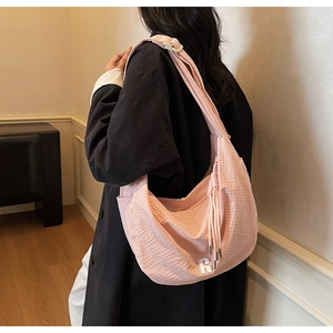 Detail of pink woven hobo bag showing the checkerboard texture and metallic letter R