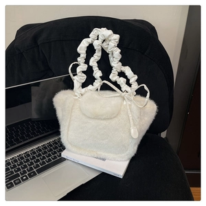 Detail view of white plush tote bag with scrunchie handle and decorative bow on the side