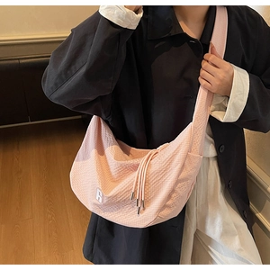 Close-up of pink waffle texture fabric bag with tassel detail and white logo