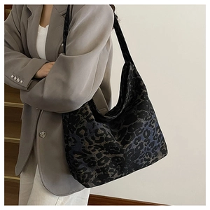 Detail shot of oversized leopard print tote bag with soft crescent shape on a model