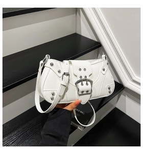 Détail du sac hobo blanc Y2K avec boucles argentées et rivets sur cuir brillant