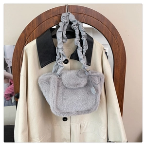 Detail of grey faux fur handbag with cloud-shaped pleated leather strap on a trench coat