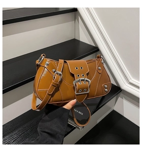 Détail du sac vintage marron avec texture en cuir brillant et boucles métalliques