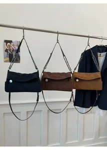 Detail of crossbody bags in black, dark coffee and tan with quilted suede finish