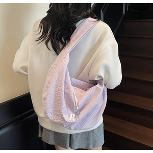 Detail of light purple waffle fabric hobo bag showing texture and white number 6 patch