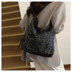 Detail of oversized leopard print tote bag in dark blue and black canvas on model