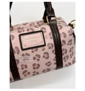 Detail of pink leopard cylinder bag featuring durable scratch-resistant texture and handle