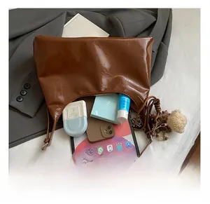 Detail view of large capacity brown tote bag interior with tablet and cosmetics